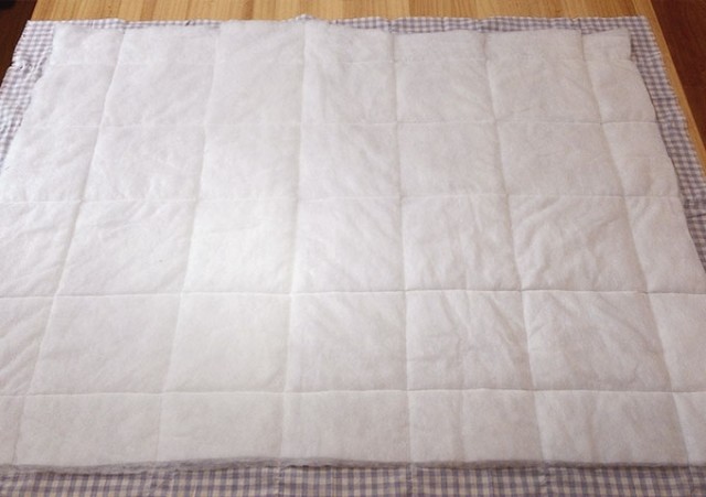 把鋪棉放在表布的背面，鋪棉要比表布四邊小約3cm，用夾子或珠針固定。